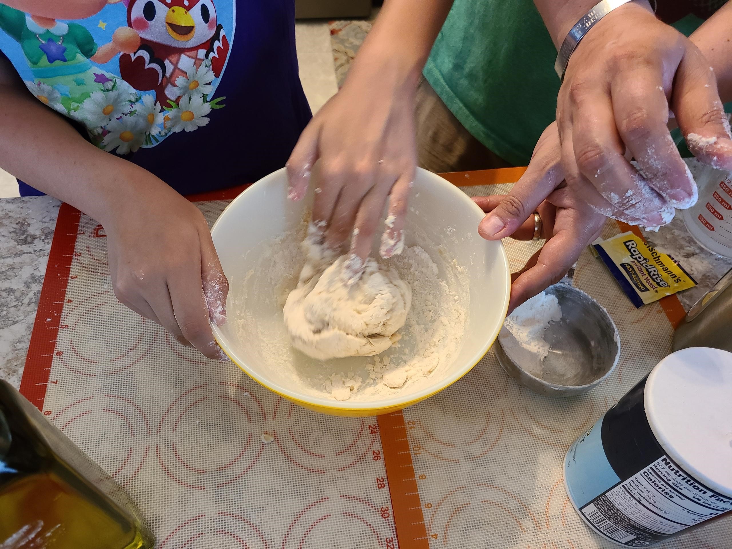 Participant kneading pizza dough.